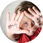 boy holding up hands with stop bullying written on them